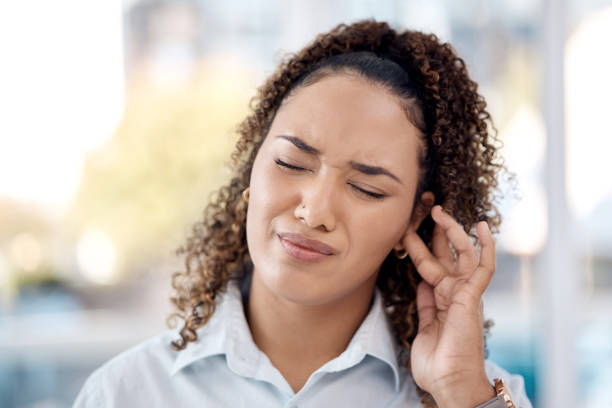 A person finding relief from ear pain by applying a warm compress to their ear.